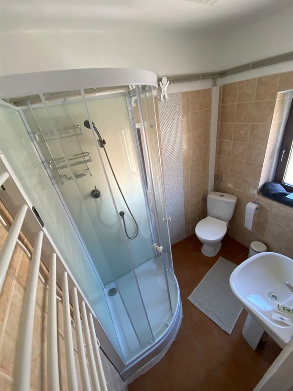 Bagno con box doccia angolare, lavabo, WC, scaldasalviette e finestra