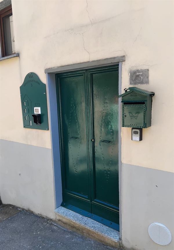 Portone verde della palazzina con cassetta delle lettere e cassetta di sicurezza per le chiavi